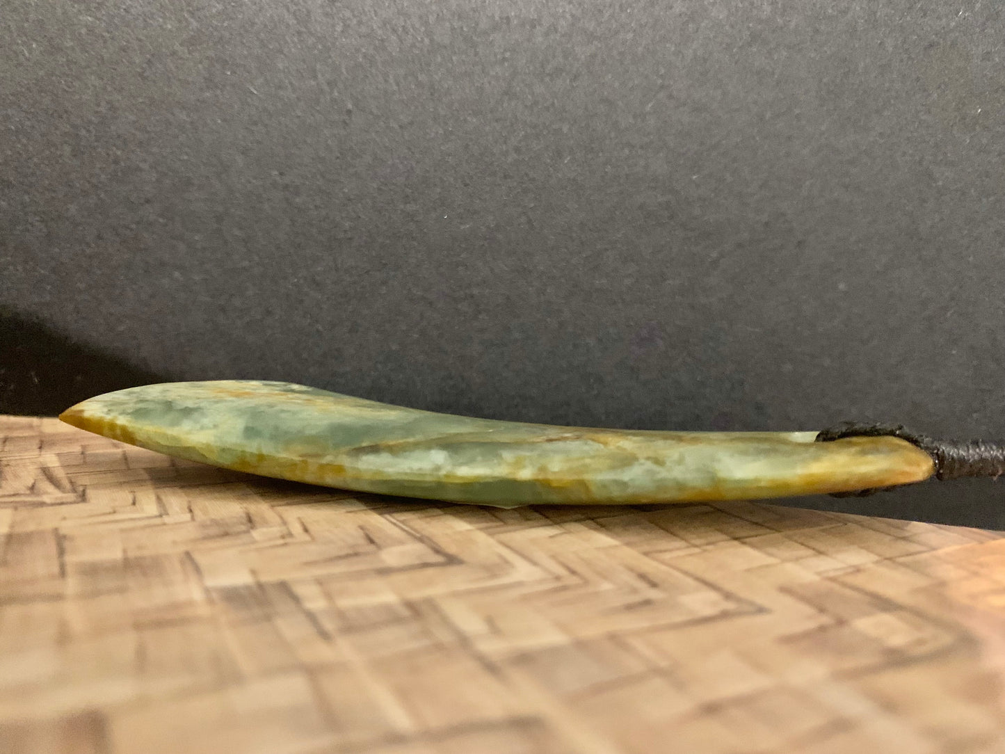 showing the curve of the Maori Pounamu hei toki pendant from New Zealand available to purchase