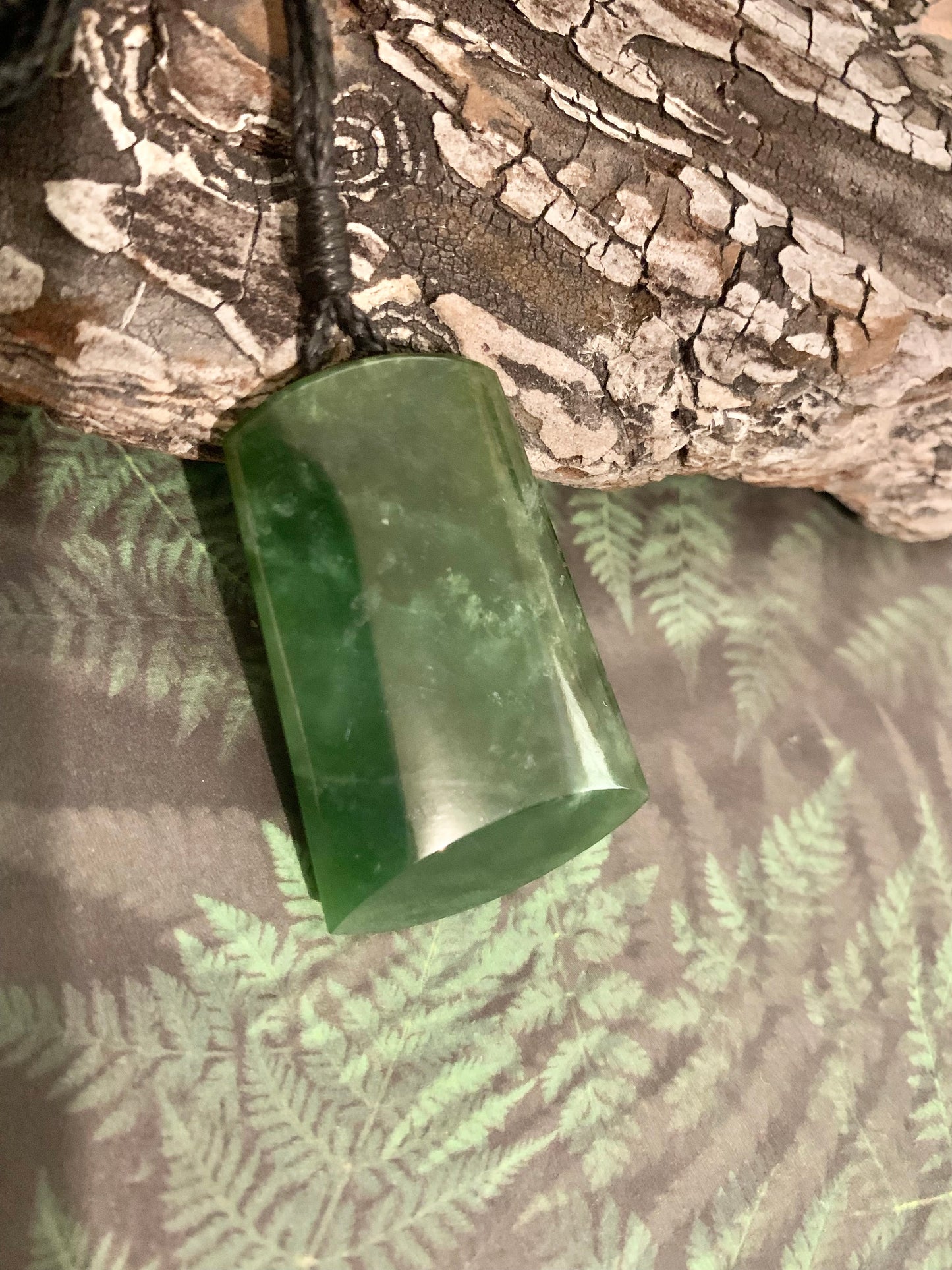 side view of Maori Pounamu hei toki adornment from New Zealand available at Silver Fern Gallery