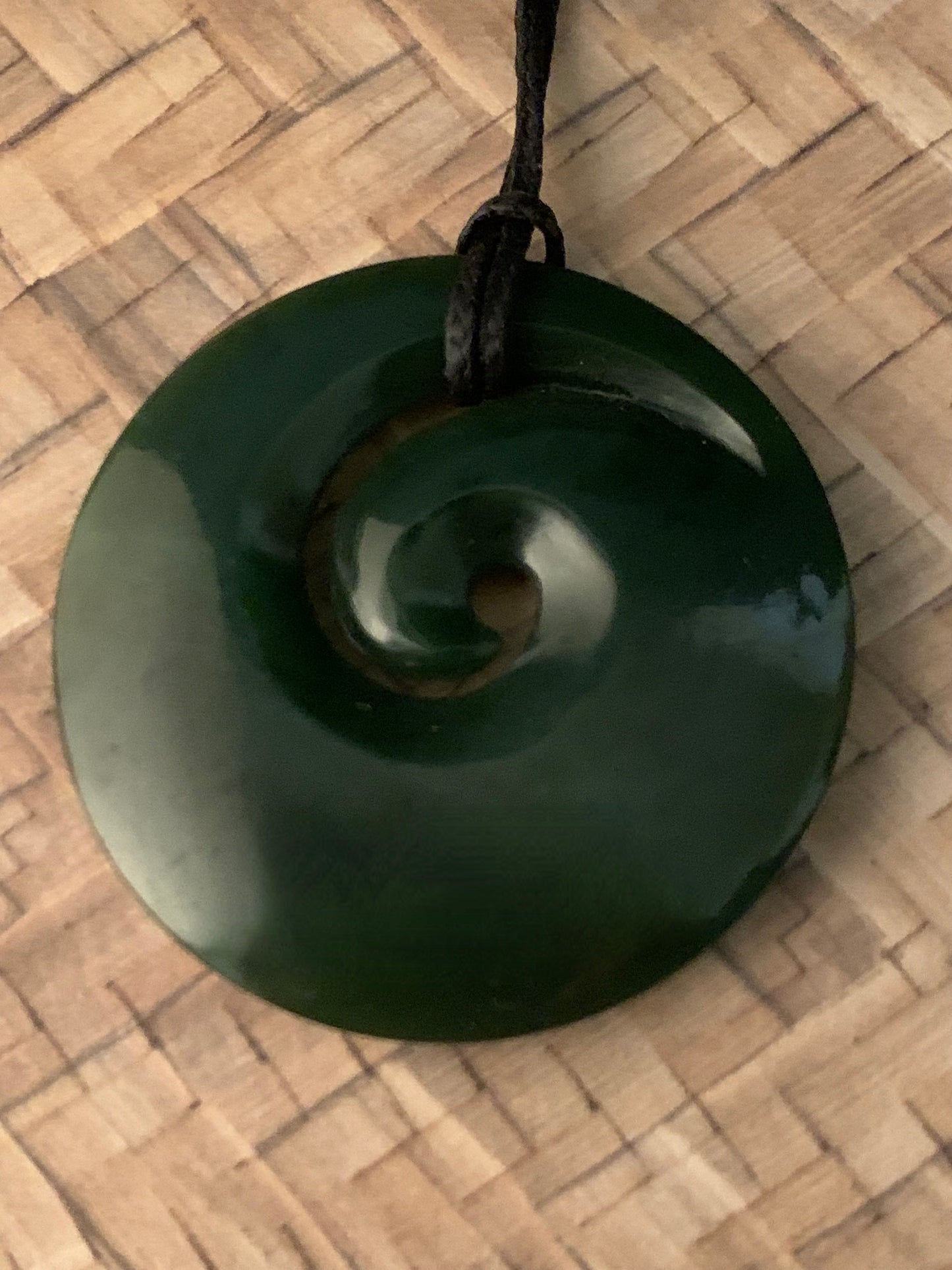 front view of New Zealand Maori koru spiral pounamu adornment available from Silver Fern gallery