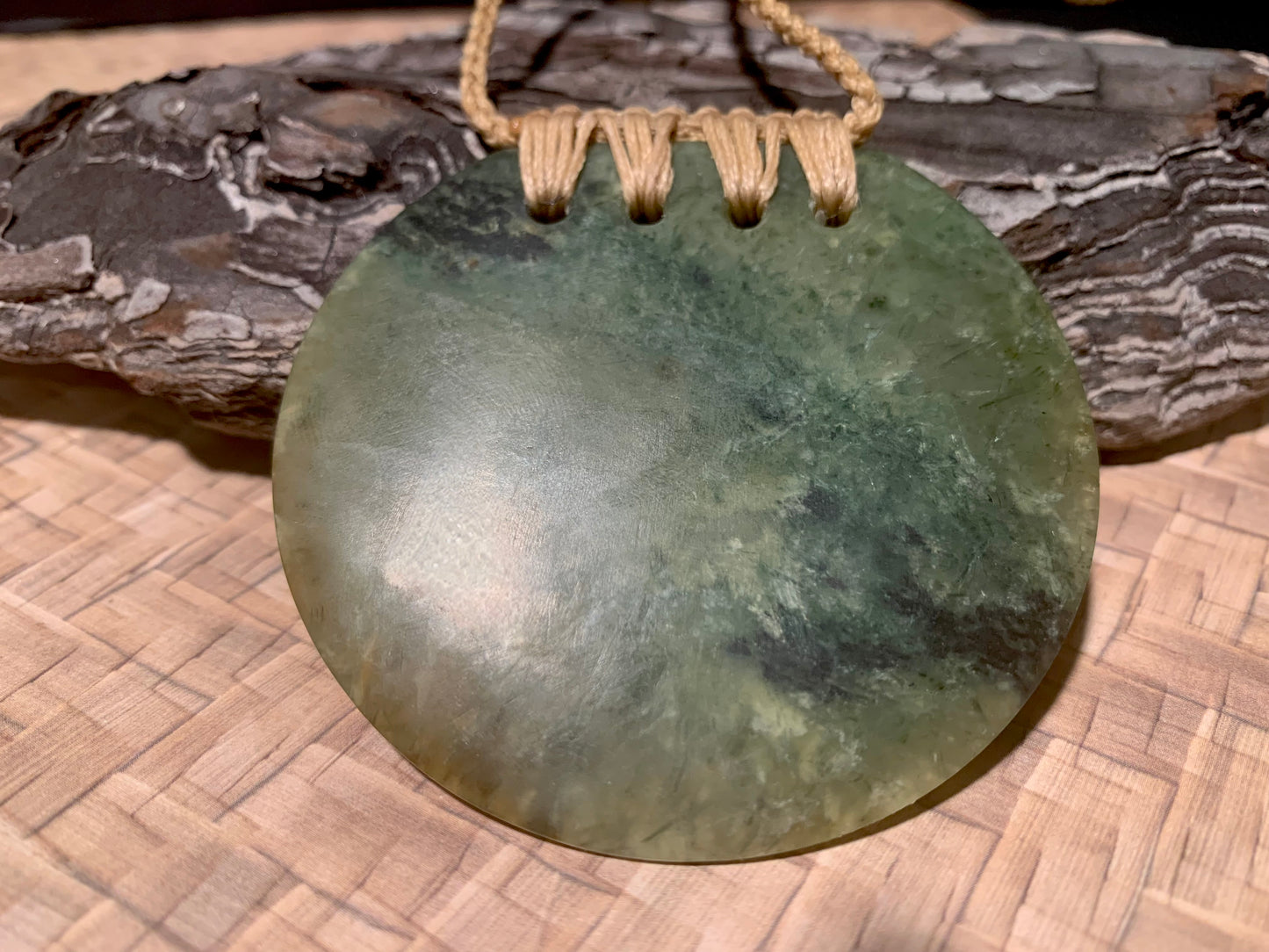 reverse view of Pounamu Koru Porohita disc carved by Alex Sands 62mm