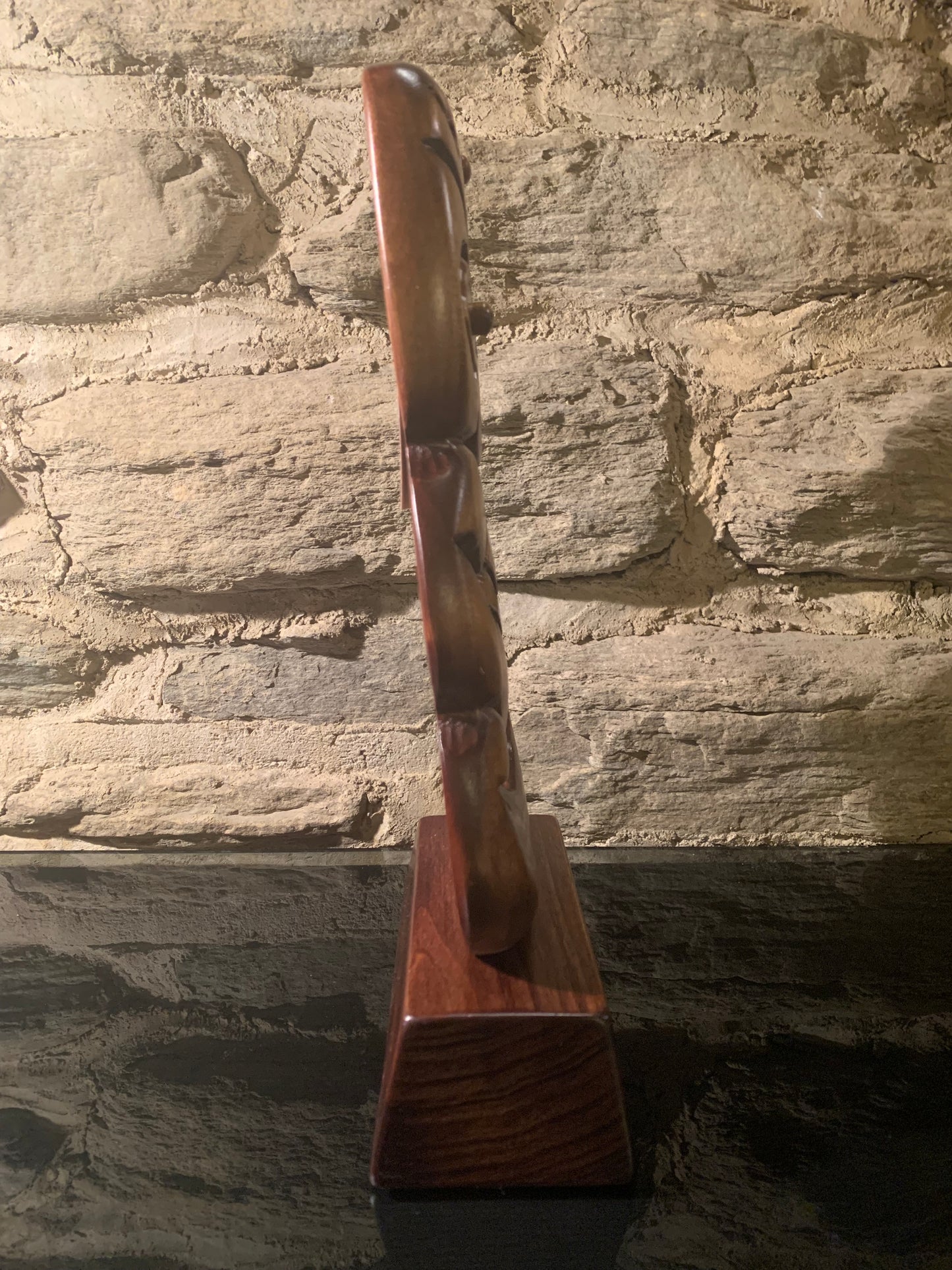 side angle of small Maori tiki on base carved in New Zealand and available from Silver Fern Gallery