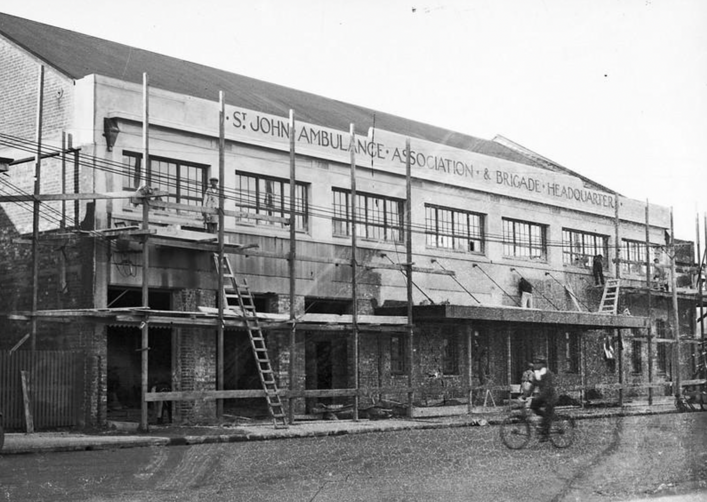 Historical black and white photo of a building with 'St. John Ambulance Association & Brigade Headquarters' signage.