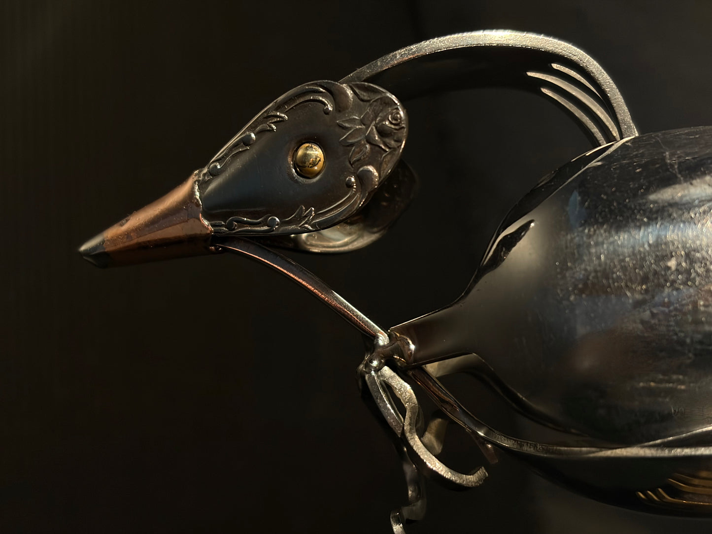 Close-up of a decorative metal NZ tui head with intricate details.