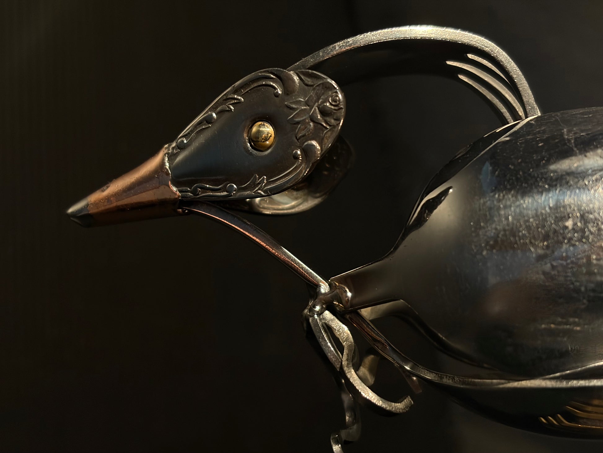 Close-up of a decorative metal NZ tui head with intricate details.