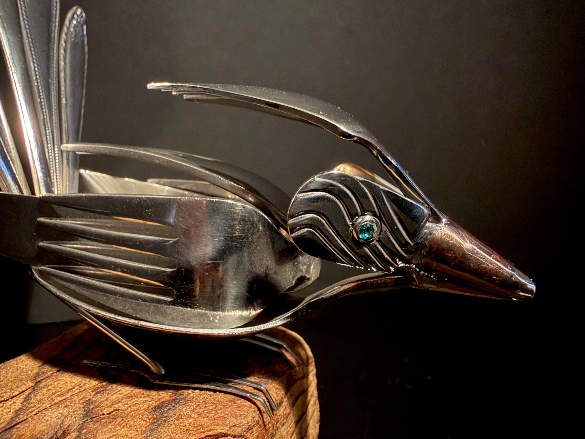Metallic NZ fantail bird ornament made from used cutlery utensils.
