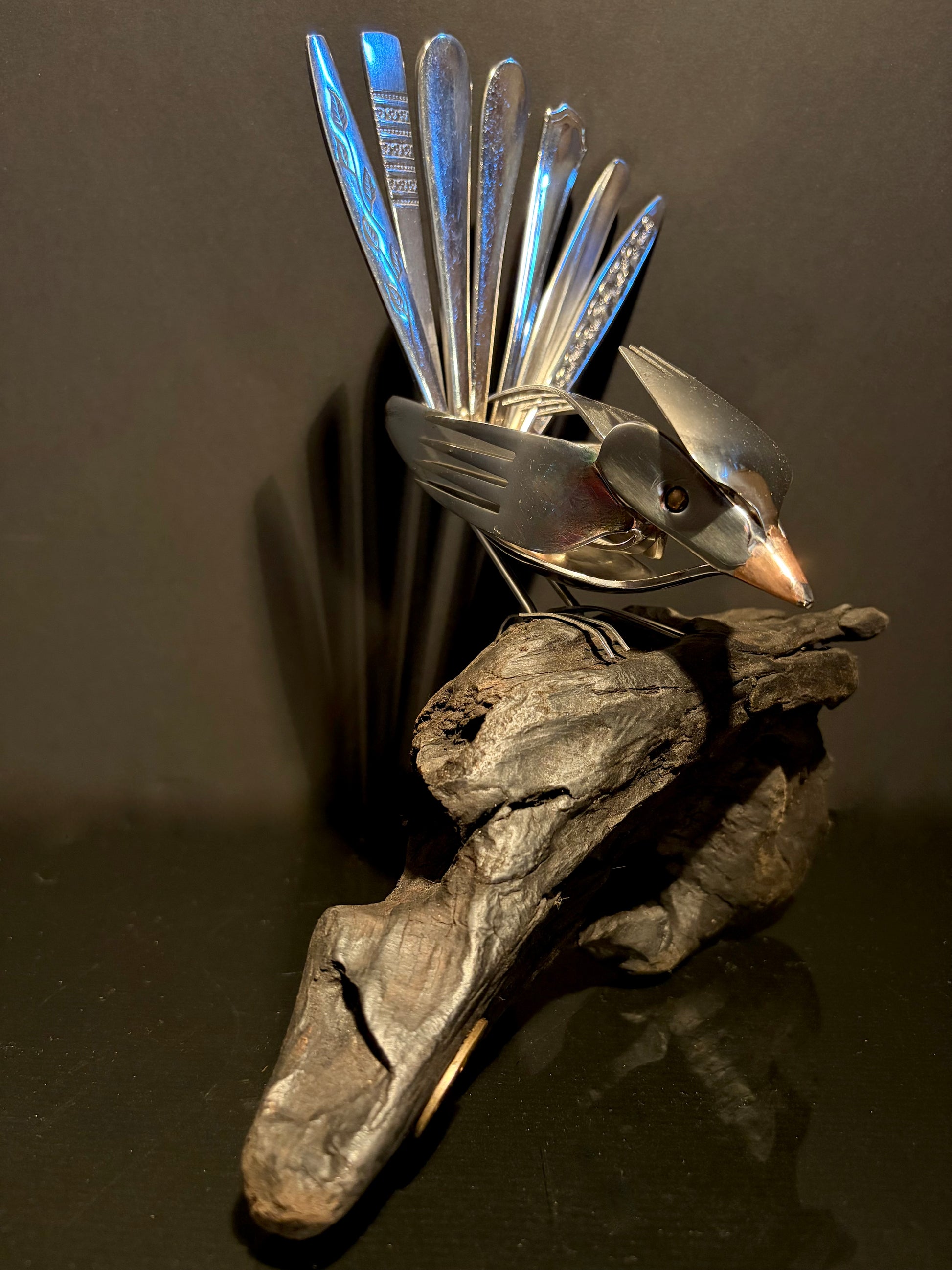 Metallic bird sculpture made from utensils.