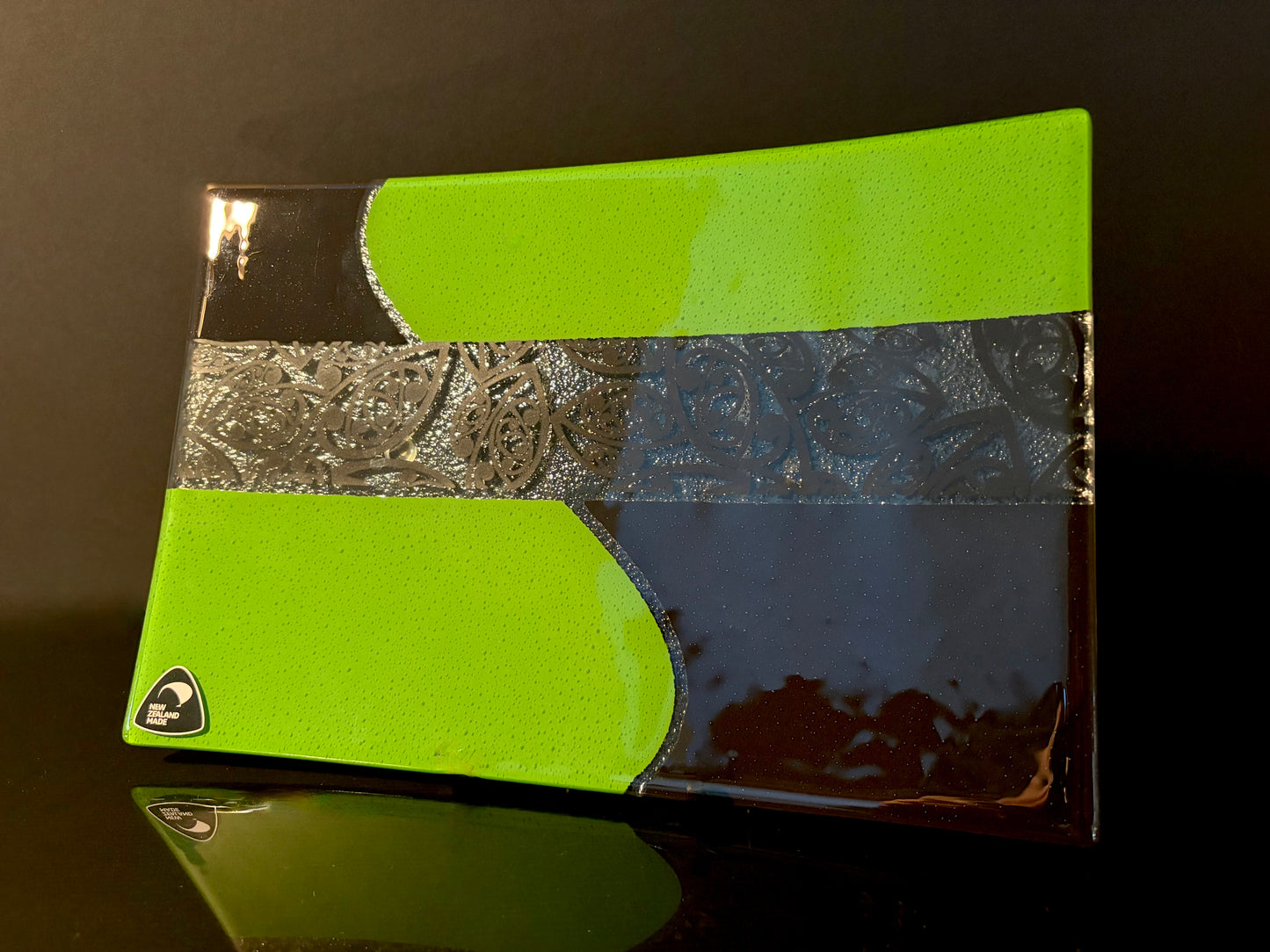 angle view of green and black rectangular fused glass plate with maori kowhaiwhai pattern 