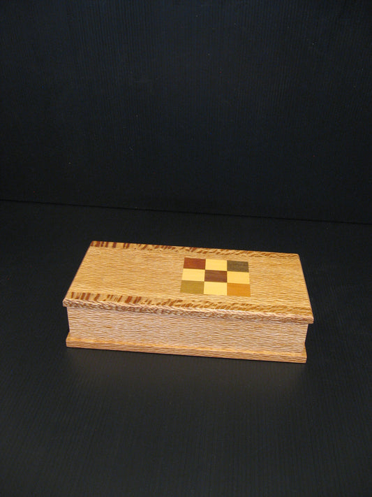 A rectangular wooden keepsake box with a checkerboard inlay on the lid.