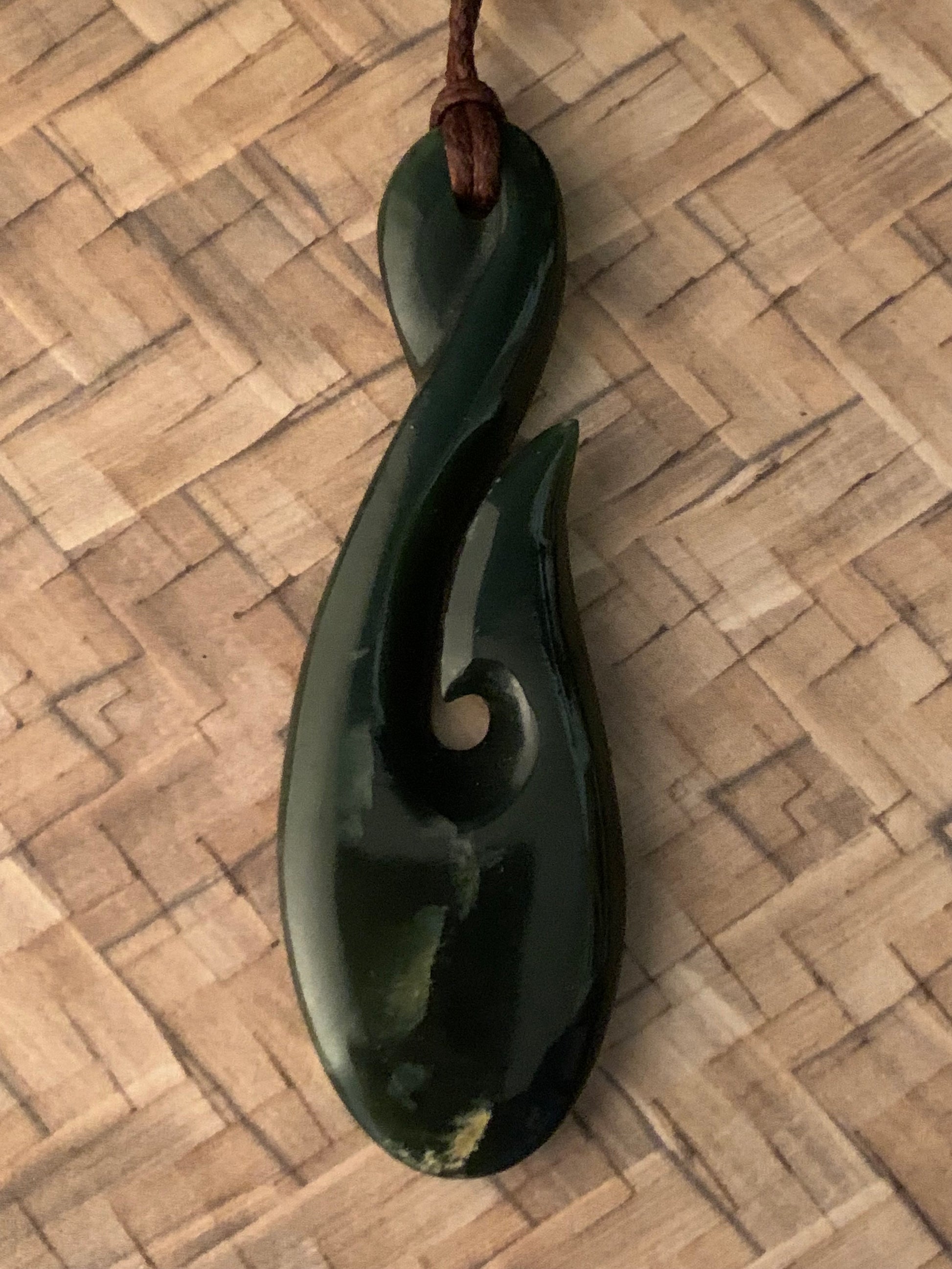 dark green Maori made hei matau fish hook from New Zealand Pounamu greenstone jade