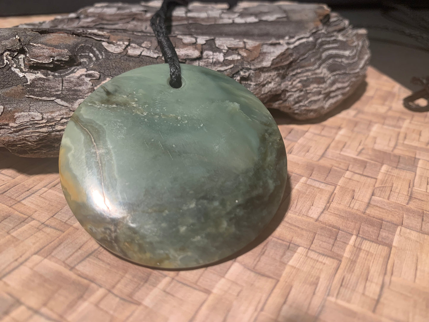 back view of Pounamu Koru Porohita disc carved by Alex Sands 50mm