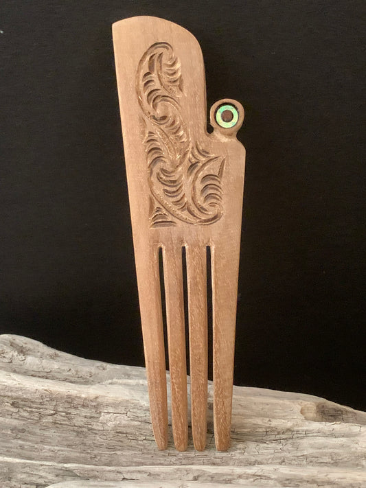 A wooden hair comb with intricate carving which can be worn or adored as taonga