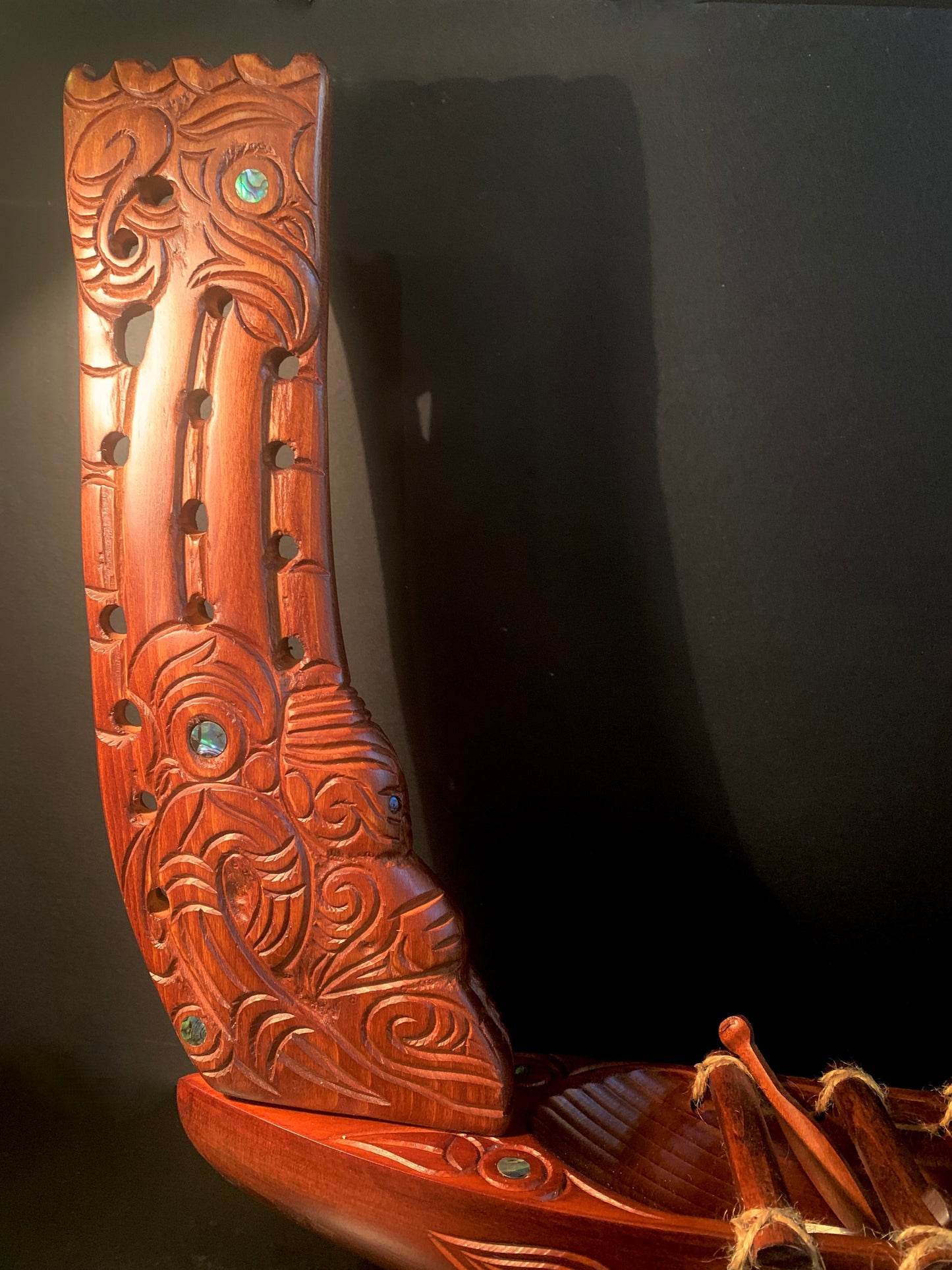 Close-up of a carved wooden Maori waka (canoe) stern with intricate carvings