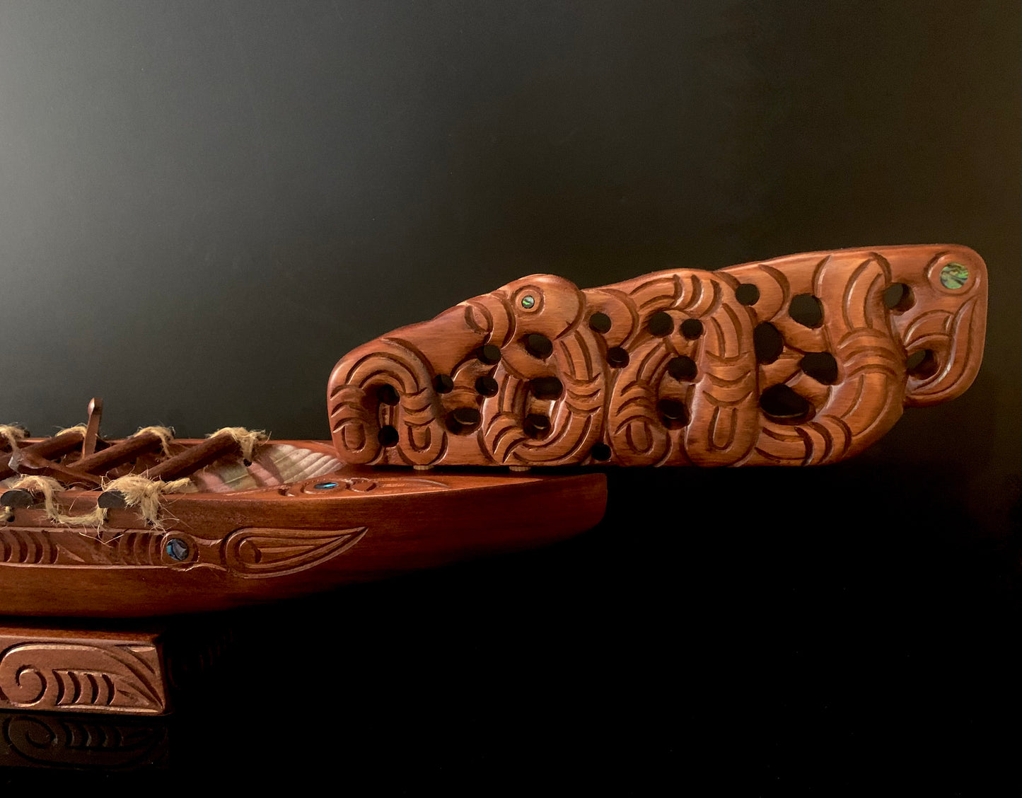 Close-up of an intricately carved wooden decorative prow with detailed relief carvings