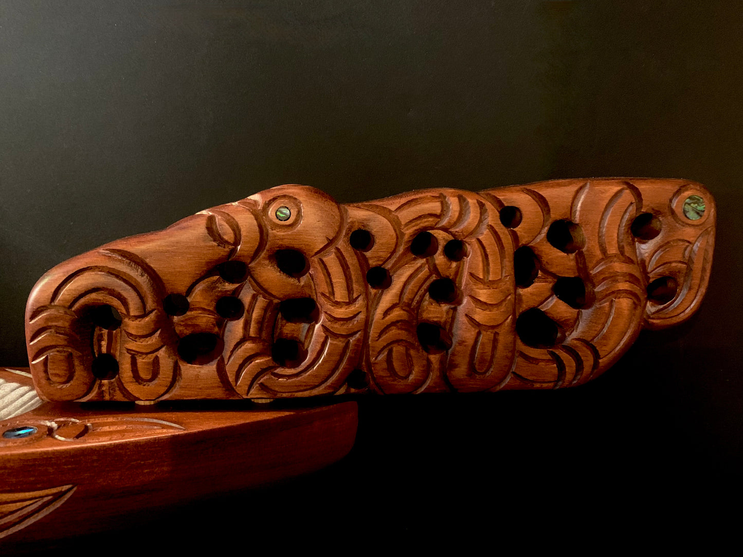 An intricately carved wooden prow with traditional Polynesian-style motifs