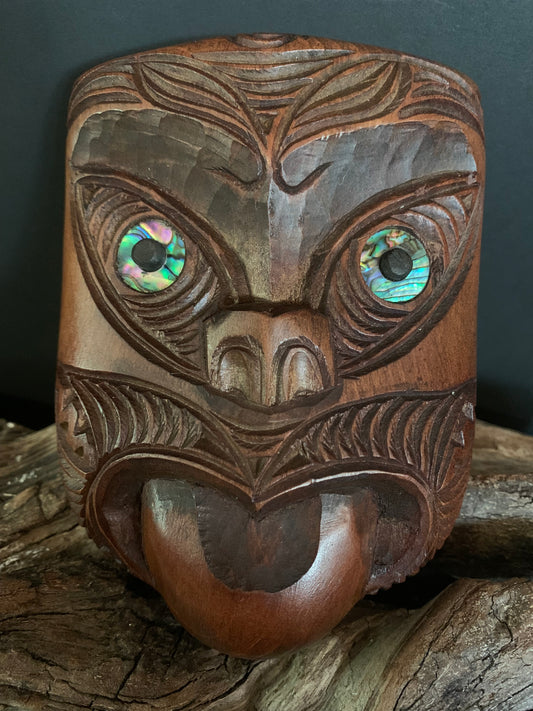 Carved wooden mask with intricate patterns and colorful eyes