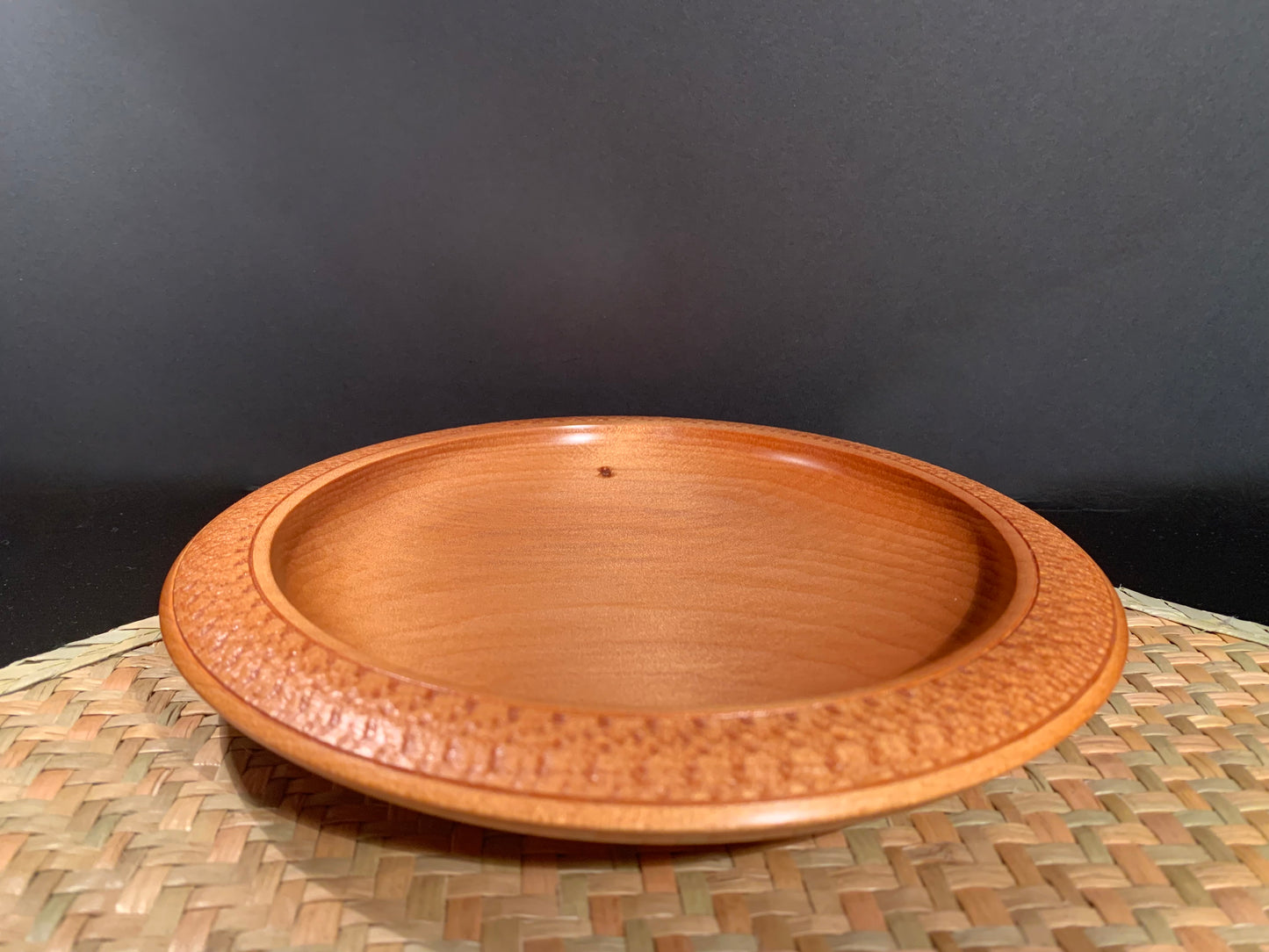 Wooden plate made from recycled kauri wood showing feature nail hole. 