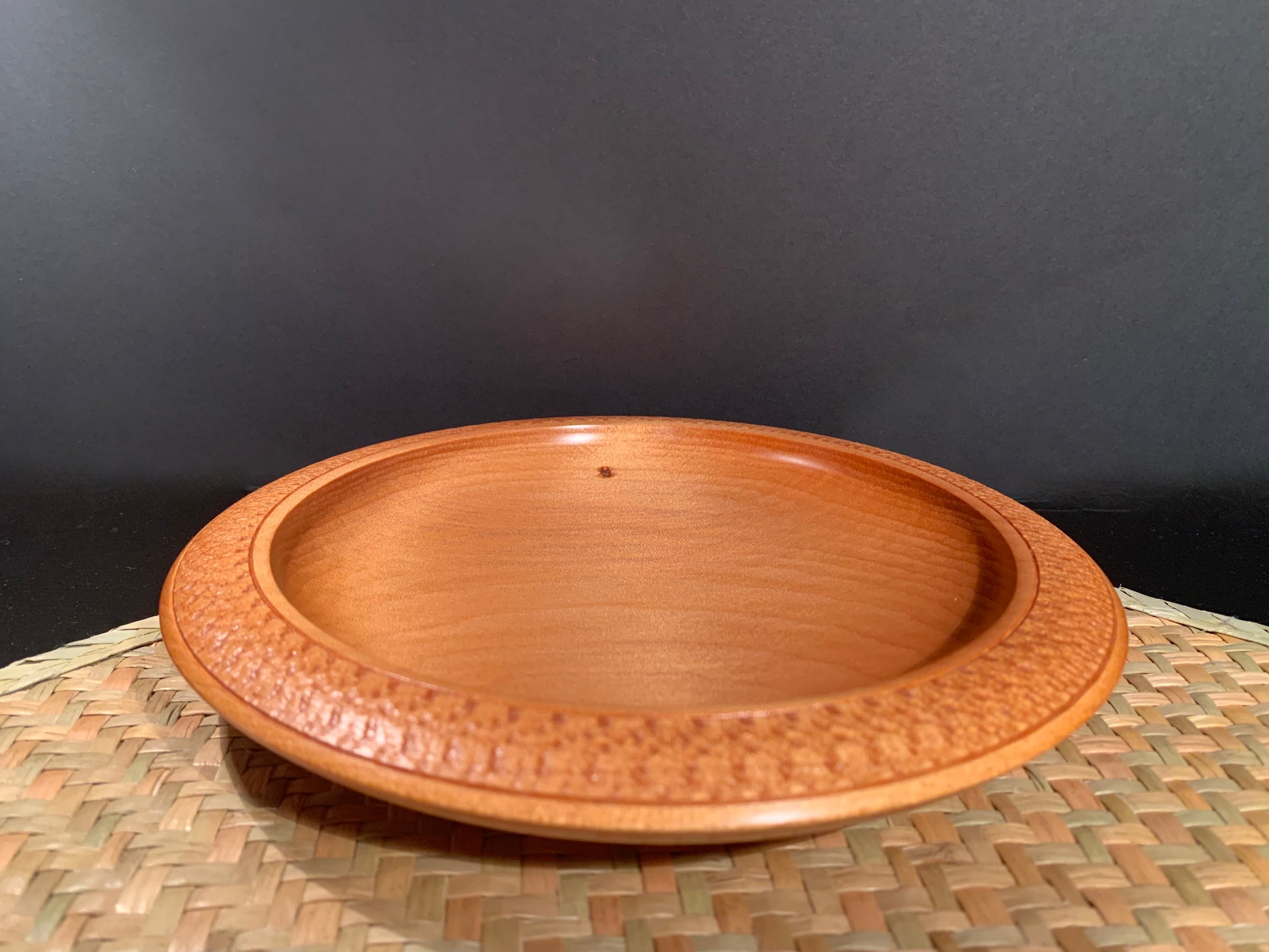 Wooden plate made from recycled kauri wood showing feature nail hole. 