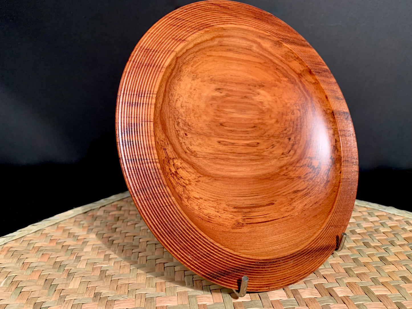 Wooden plate with hand tooled detailed rim.