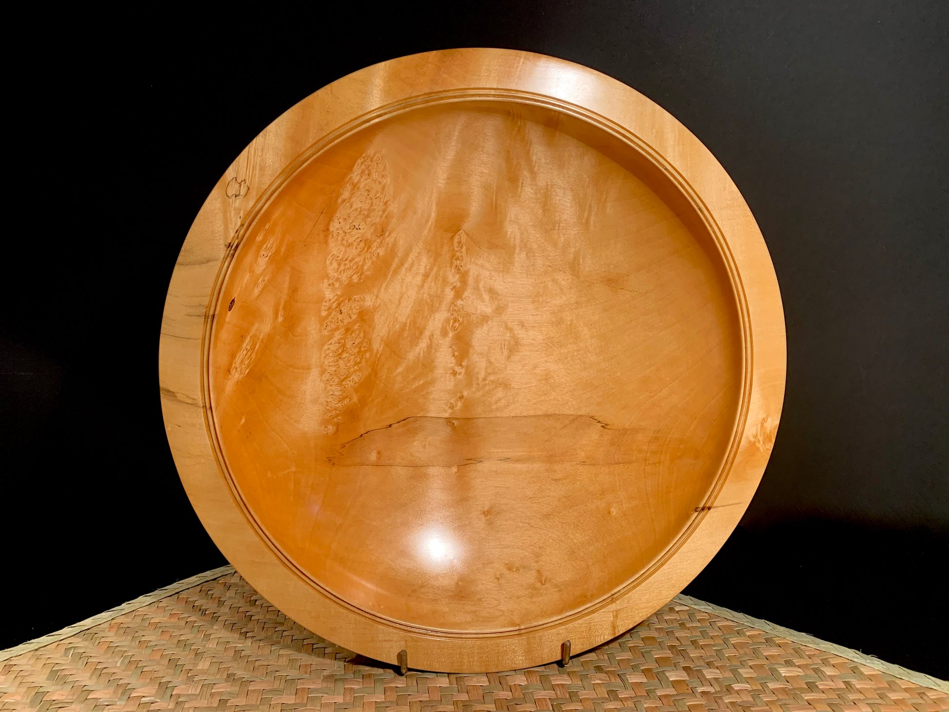 Wooden bowl on a textured surface with a dark background