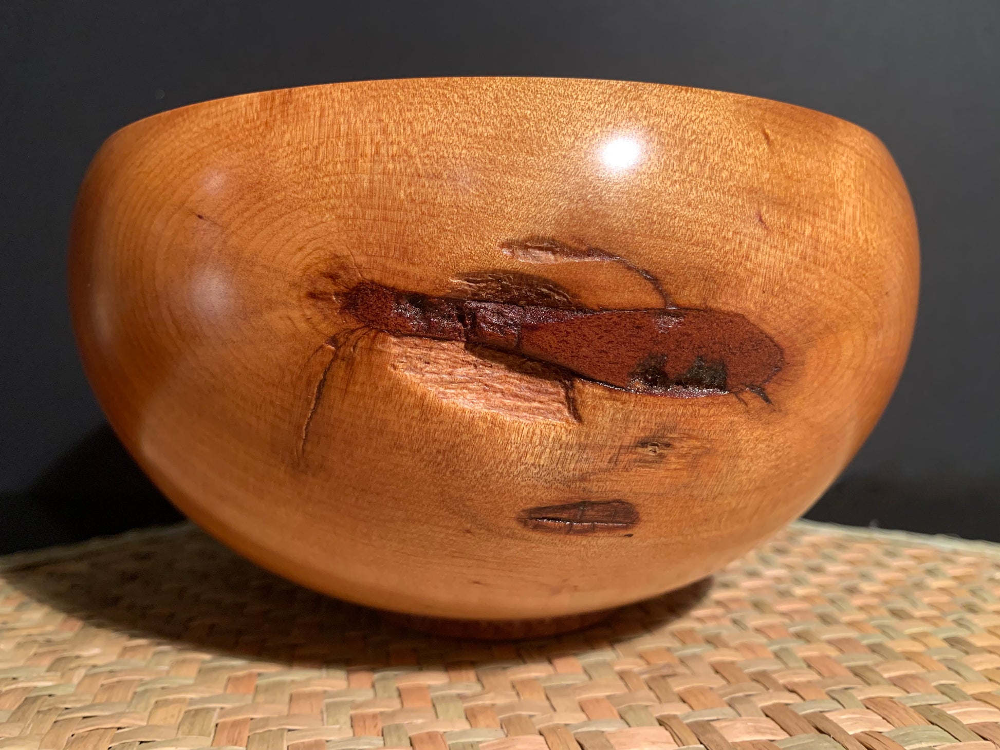 Wooden bowl with natural defect feature in the wood.