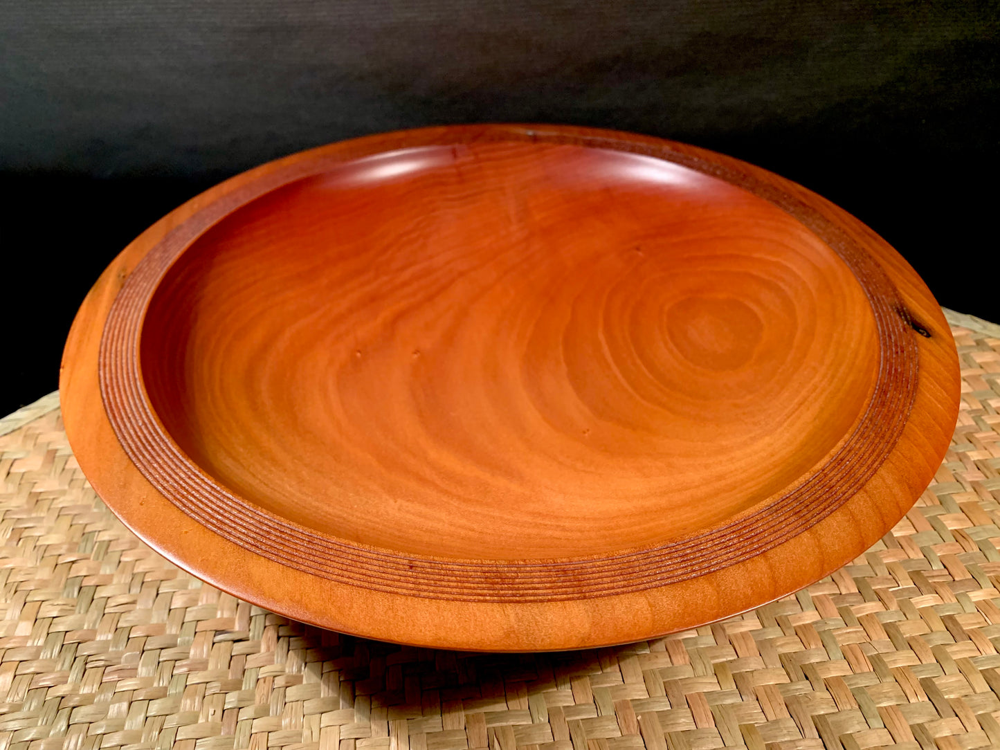 Wooden bowl with a natural grain pattern and grooved rim.