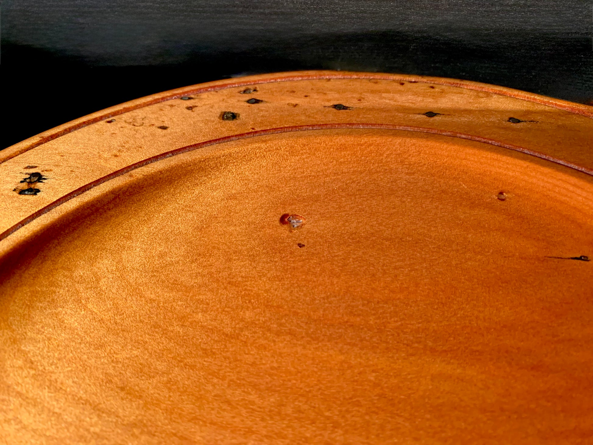 Close-up of a wooden plate surface with cut nail character features. 
