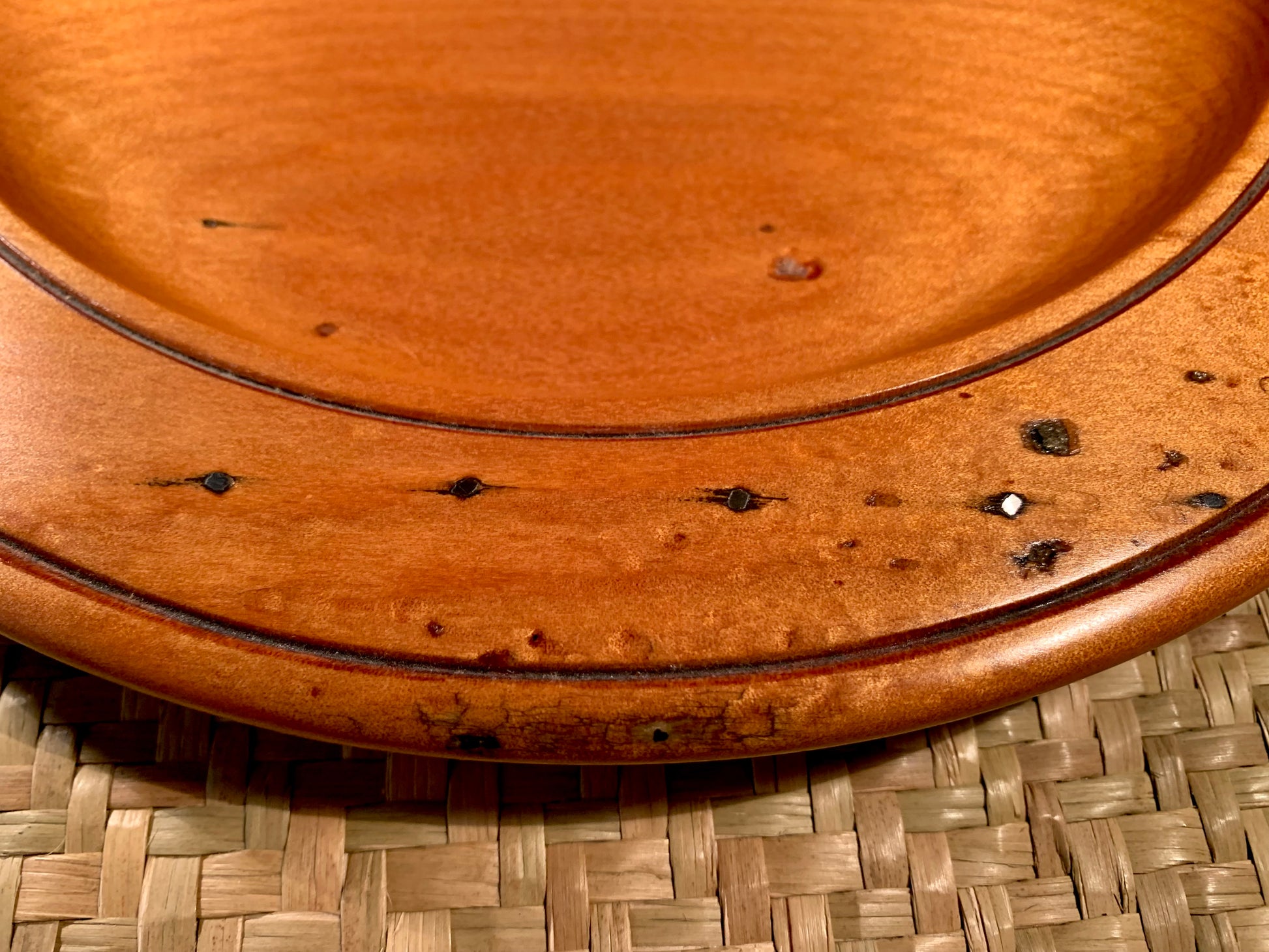 Close-up of a wooden plate with a woven surface background.