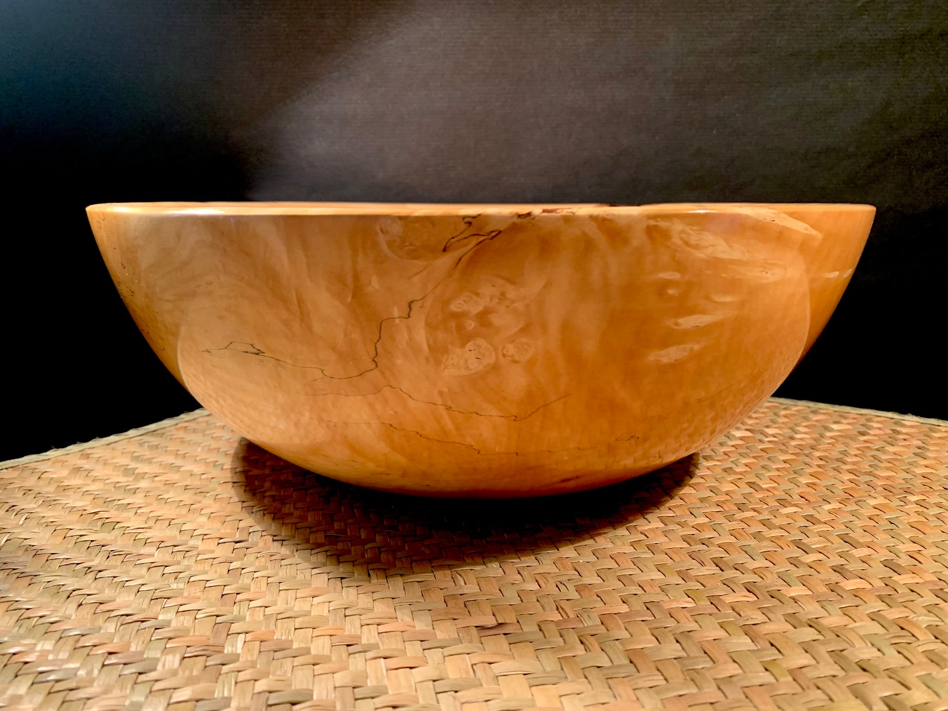 Wooden bowl on a woven surface.