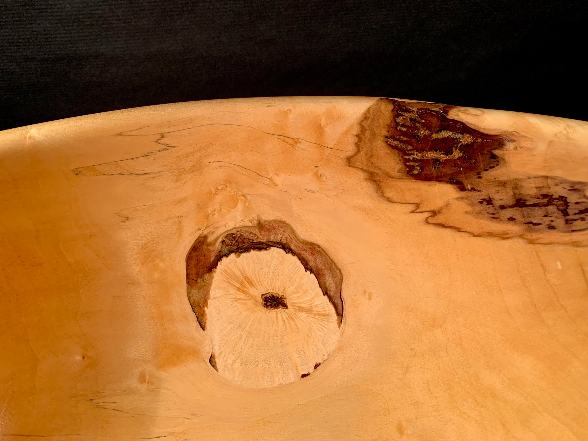 Inside a wooden bowl with a wood knot.
