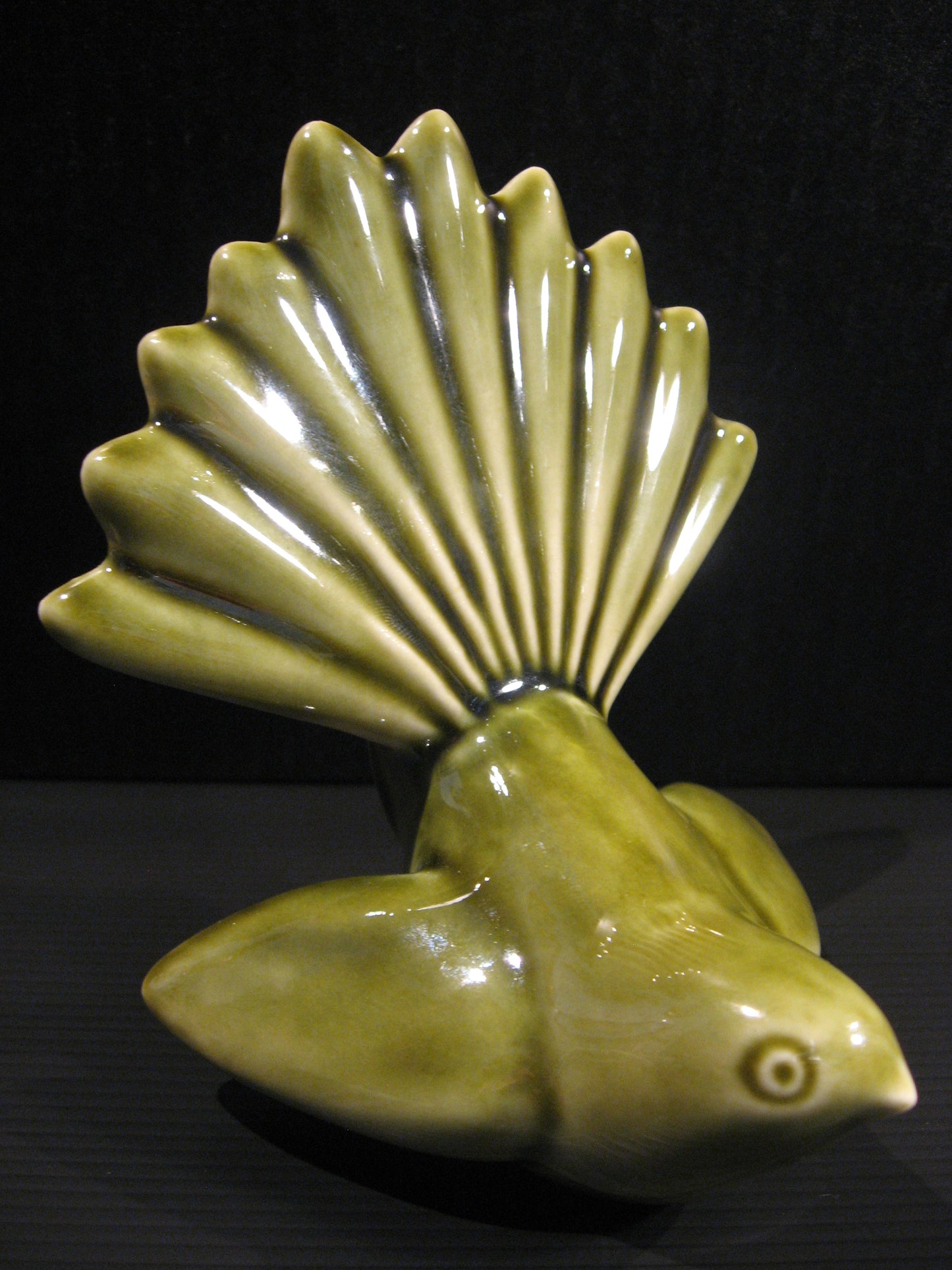 Side view of Ceramic Piwakawaka (Fantail) by Bob Steiner (moss green) Silver Fern Gallery